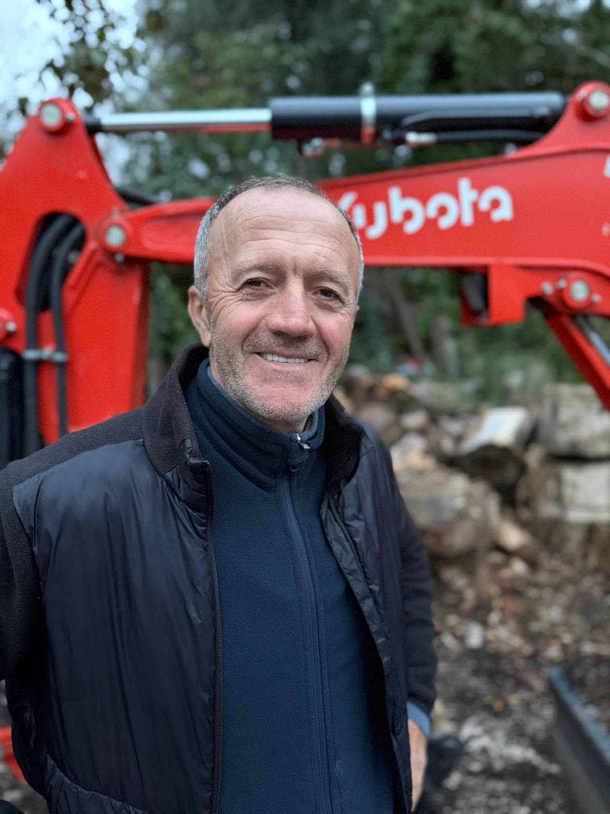 Ilirian Marku, Inhaber von Marku Bau, vor einem Minibagger